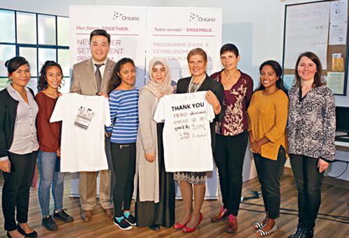 罗鬓妮(右四)与移民中心人员合照。左三为安省省议员董晗鹏。(加拿大《星岛日报》)